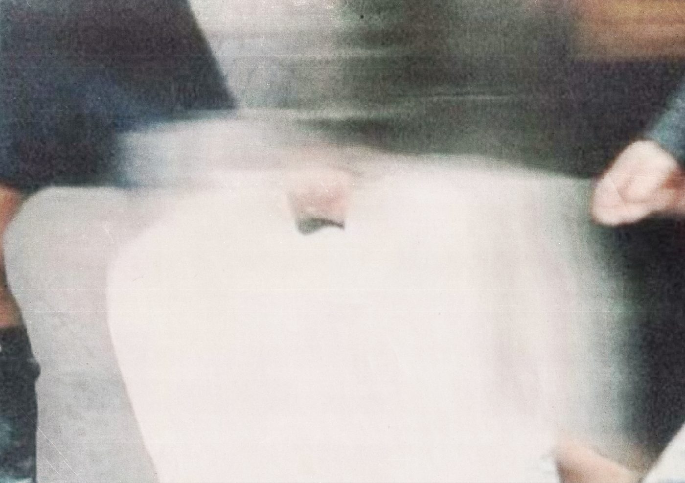A freshly finished white garment held up for inspection